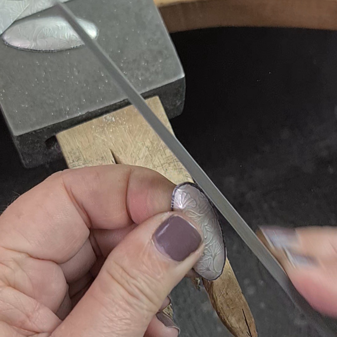 image shows the edges of a silver oval being filed